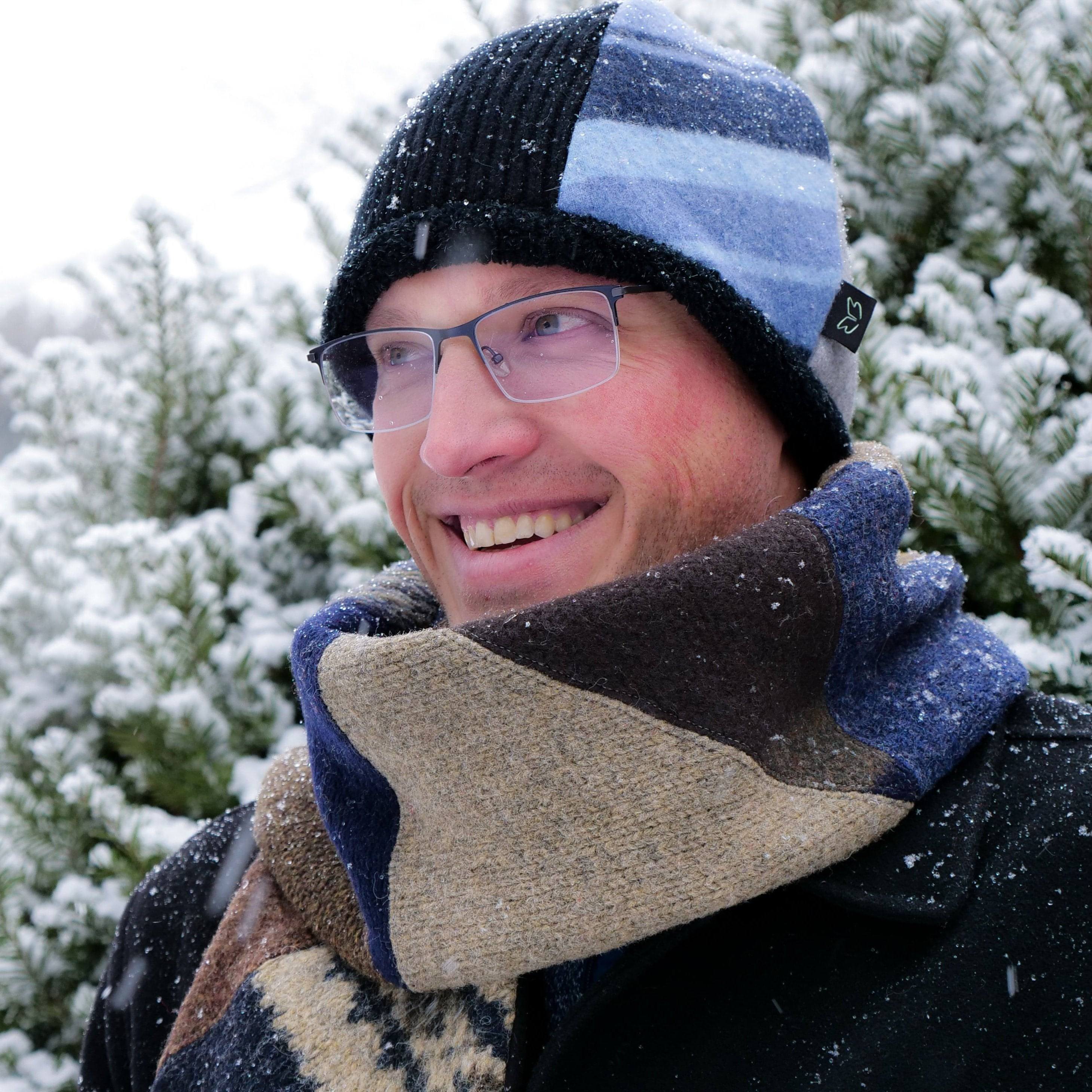 man standing outside in snow wearing a baabaazuzu knit scarf and beanie