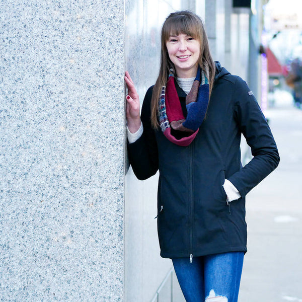 woman leaning on wall wearing a skinny infinity scarf