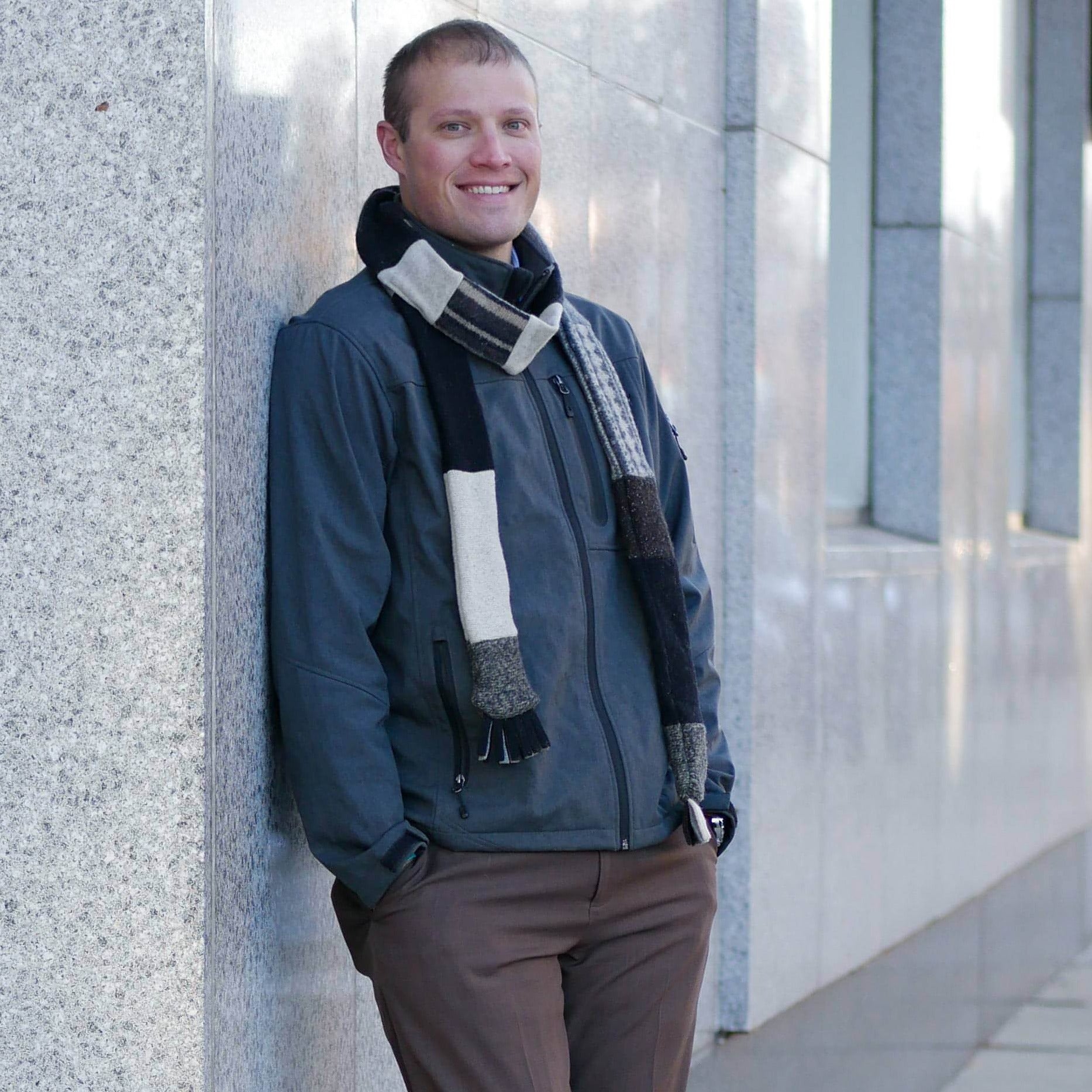 man standing wearing neutral colored skinny scarf